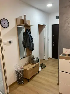 a room with a mirror and a dresser and a clock at Apartman Popović in Ruma