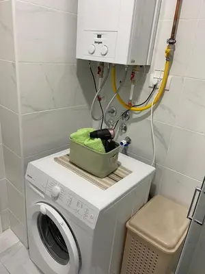 a washing machine with a green basket on top of it at Apartman Popović in Ruma