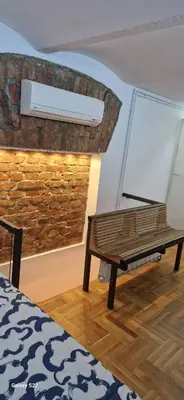 a room with a bench next to a brick wall at Micro in Belgrade