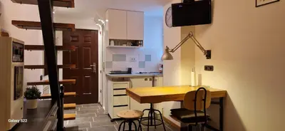a small kitchen with a wooden table and chairs at Micro in Belgrade