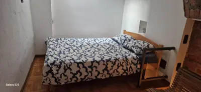 a small bedroom with a bed with a blue and white blanket at Micro in Belgrade