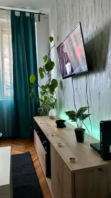 a room with a wooden desk with a tv on the wall at Apartman Moon in Belgrade