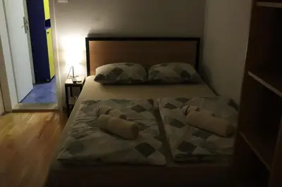 a bed with two pillows on it in a bedroom at Apartments Peka in Dušanovac (historical)