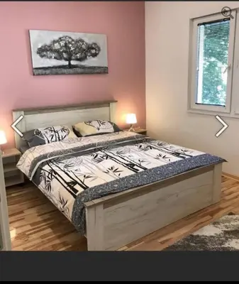 a bedroom with a bed with a tree on the wall at Apartman 4 you Downtown in Belgrade