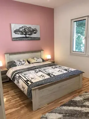 a bedroom with a bed with a tree on the wall at Apartman 4 you Downtown in Belgrade