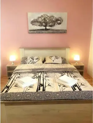a bedroom with a bed with two lamps on it at Apartman 4 you Downtown in Belgrade