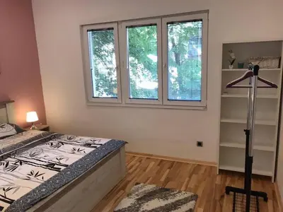 a bedroom with a bed and two windows at Apartman 4 you Downtown in Belgrade