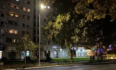 a city street at night with a building and a street light at Arena Belgrade in Novi Beograd