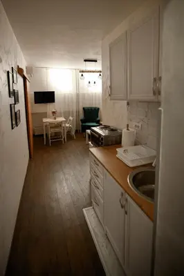 a kitchen with white cabinets and a sink and a table at Arena Belgrade in Novi Beograd