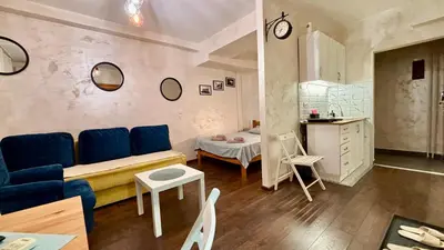 a living room with a blue couch and a kitchen at Arena Belgrade in Novi Beograd