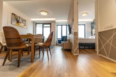 a living room with a dining room table and chairs at Apartments Royal - Sakura Park in Novi Beograd