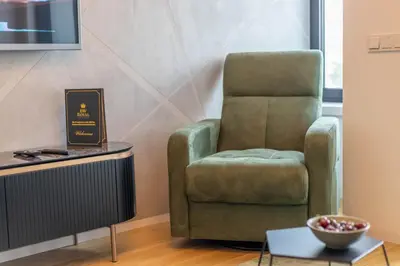 a green chair in a living room next to a table at Apartments Royal - Sakura Park in Novi Beograd