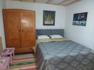 a bedroom with a bed and a wooden cabinet at Imanje sa bazenom in Obrenovac