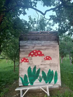 a wooden bench with mushrooms painted on it at Imanje sa bazenom in Obrenovac
