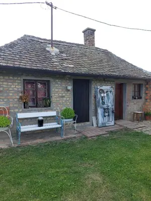 a house with a bench in front of it at Imanje sa bazenom in Obrenovac