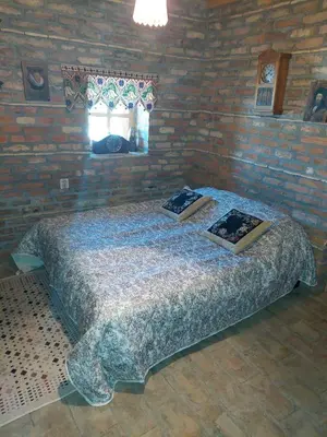 a bedroom with a large bed in a brick wall at Imanje sa bazenom in Obrenovac