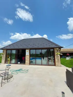 a pavilion with a roof with a pool at Imanje sa bazenom in Obrenovac