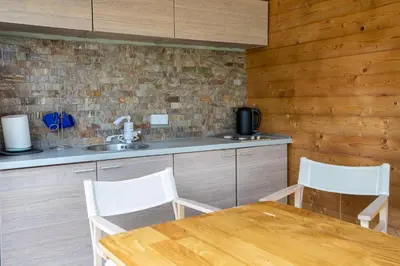 a kitchen with a table and chairs and a sink at Obedska Bara - Kupinovo Retreat House in Kupinovo