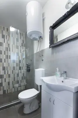 a bathroom with a white toilet and a sink at Obedska Bara - Kupinovo Retreat House in Kupinovo