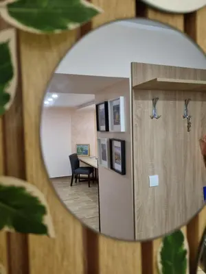 a mirror reflecting a room with a table and a chair at Apartman DoDoLuLu in Belgrade