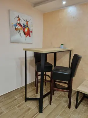 a table and chairs in a room with a painting at Apartman DoDoLuLu in Belgrade