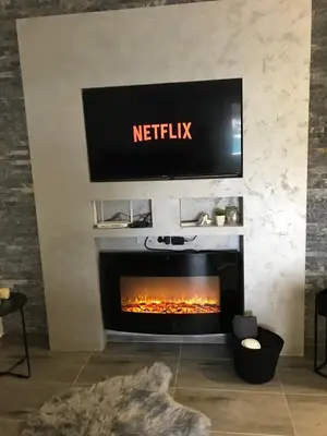 a tv above a fireplace with a television above it at Apartman Oler in Smederevo
