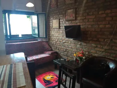a living room with a couch and a tv on a brick wall at Marmelo in Belgrade