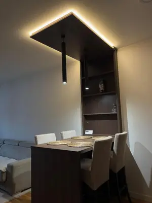 a dining room with a table with chairs and a light at Apartment SIA in Voždovac