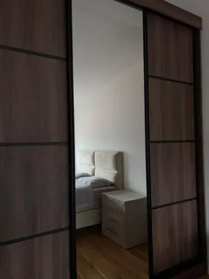 a mirror in a room with a bed and a chair at Apartment SIA in Voždovac