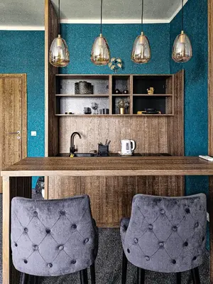a kitchen with blue walls and two bar stools at MOOW Belgrade Waterfront View Apartments in Belgrade