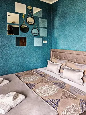 a bedroom with a large bed with blue walls at MOOW Belgrade Waterfront View Apartments in Belgrade