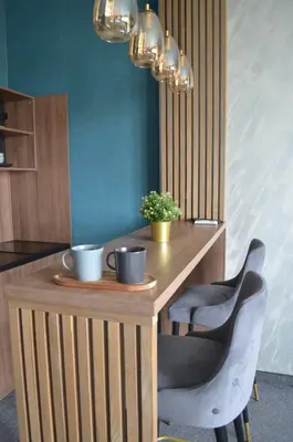 a wooden table with two cups on it with two chairs at MOOW Belgrade Waterfront View Apartments in Belgrade