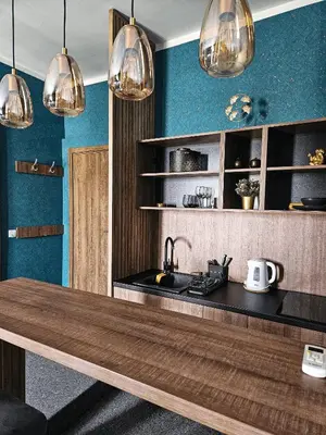 a kitchen with a wooden table and several lights at MOOW Belgrade Waterfront View Apartments in Belgrade