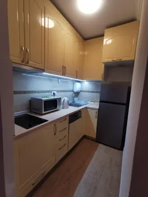 a small kitchen with yellow cabinets and a microwave at Fortuna Lux in Zvezdara