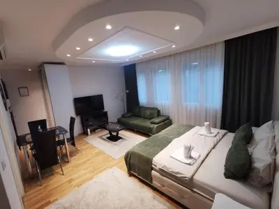 a bedroom with a large bed and a living room at Fortuna Lux in Zvezdara