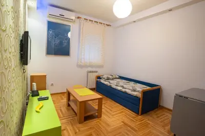 a small room with a bed and a table at Lorono Kosta in Belgrade