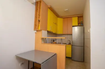 a kitchen with yellow cabinets and a refrigerator at Lorono Kosta in Belgrade