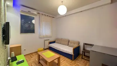 a small room with a bed and a table at Lorono Kosta in Belgrade