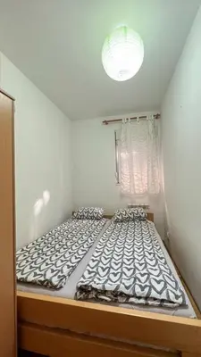 a large bed in a small room with a window at Lorono Kosta in Belgrade