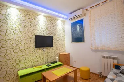 a living room with a television on a wall at Lorono Kosta in Belgrade