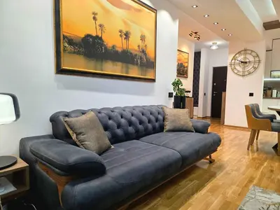 a blue couch sitting in a living room at Oaza apartmani in Arandjelovac