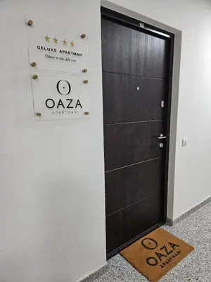 a door in a room with a sign and a welcome mat at Oaza apartmani in Arandjelovac