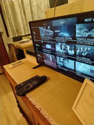 a computer monitor and a remote control sitting on a table at \ua564 Comfy Home \ua564 - Make yourself at home in Belgrade