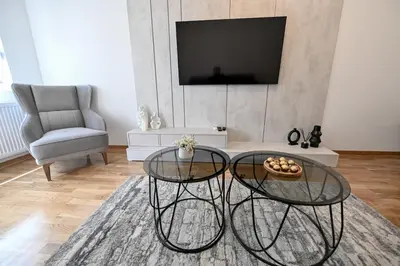 a living room with two glass tables and a tv at Porto lux in Arandjelovac