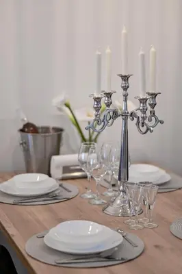 a table with candles and plates and glasses on it at Porto lux in Arandjelovac