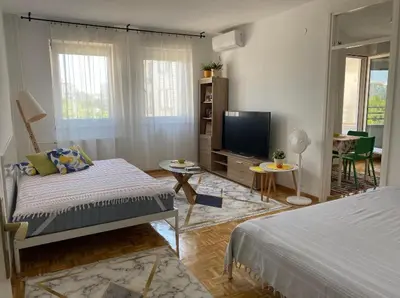 a living room with a bed and a television at Arena 011 in Novi Beograd