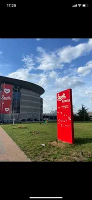 a red sign in the grass in front of a building at Arena 011 in Novi Beograd