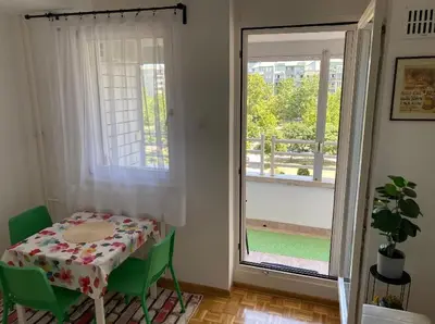 a small table and chairs in a room with a window at Arena 011 in Novi Beograd
