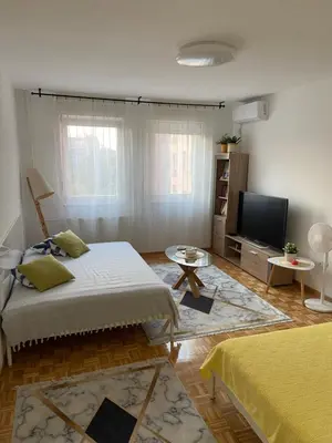 a living room with a bed and a flat screen tv at Arena 011 in Novi Beograd