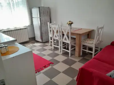 a kitchen with a table and chairs and a refrigerator at Apartment Ken 1 in Surčin